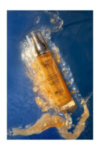 huile sèche pailletée corps et cheveux à base d'huile d'amande douce marque Exsens effet reflet doré pailleté flacon pompe en verre contenance 50ml